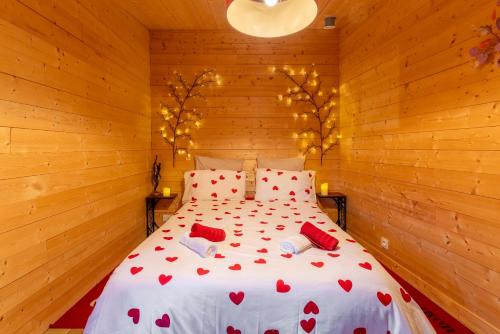 a bedroom with a bed with red hearts on it at Le Chalet Houda et spa en option in Nîmes