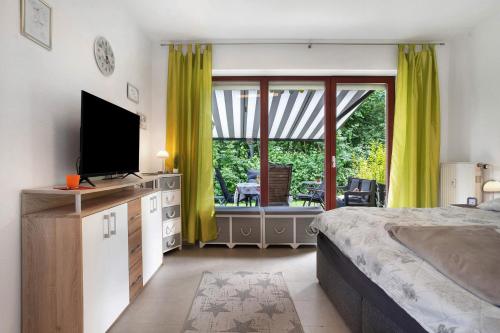 a bedroom with a bed and a flat screen tv at Ferienpark Gustow B09 in Gustow