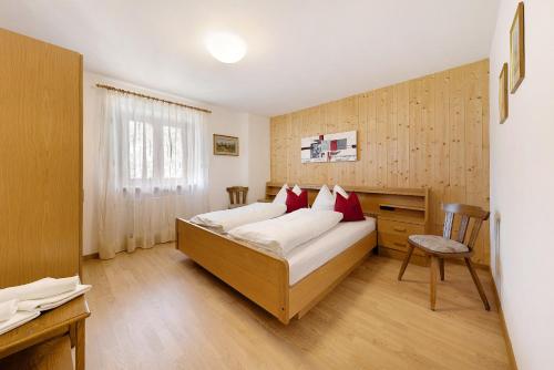 a bedroom with a bed and a desk in it at Moar im Rumsein - Apt Saltenblick in Terlano