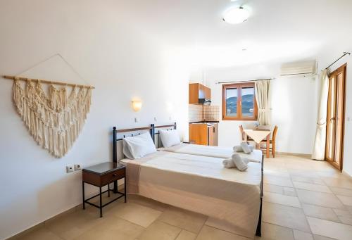 a bedroom with a large bed and a table at Petra Studios in Karpathos