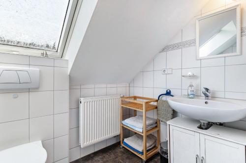 a white bathroom with a sink and a window at Ferienwohnung Moritz in Lahr