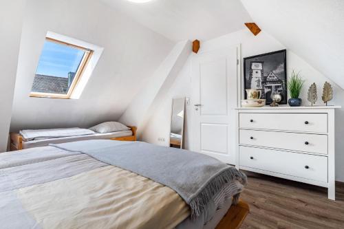 a bedroom with a bed and a dresser and a window at Ferienwohnung Moritz in Lahr