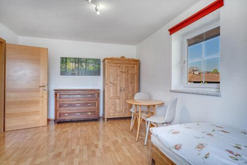 a bedroom with a bed and a table and a window at Haus Reichl in Berndorf bei Salzburg