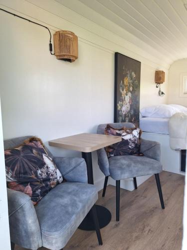 ein Zimmer mit einem Tisch, zwei Stühlen und einem Bett in der Unterkunft Westerhoeve in Petten