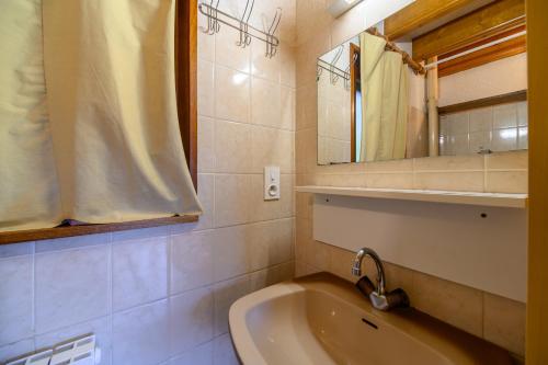 a bathroom with a sink and a mirror and a tub at Les Chalets Du Pres D'amont in Vagney