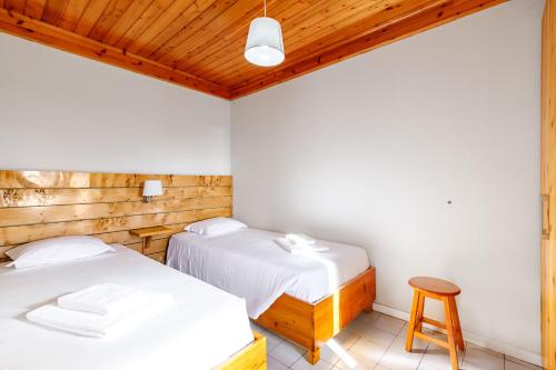 two beds in a room with wooden ceilings at Casa da Praya in Horta