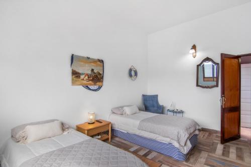two beds in a room with white walls at Vv Suite Las Velas in Gáldar