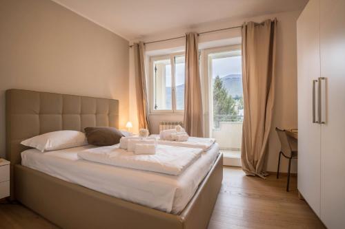 a bedroom with a large bed with a window at Residence La Villa Tesoro in Tignale