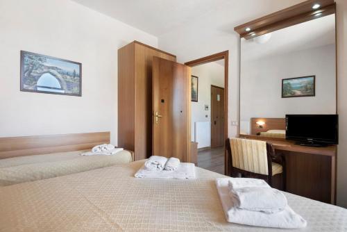 a hotel room with two beds and a desk with a computer at Appartamento Bilocale Moneglia 37 in Moneglia