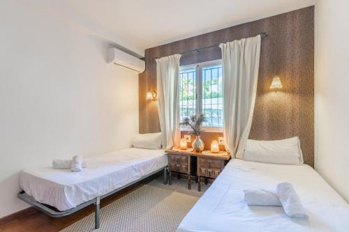 two beds in a room with a window at Casa Sillero Dos in Moraira