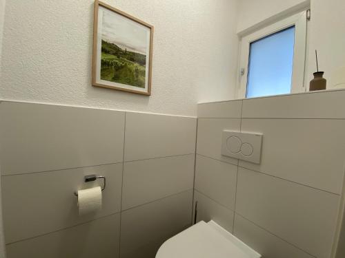 a white bathroom with a toilet and a window at Myzell in Radolfzell am Bodensee