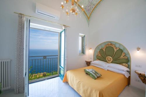 a bedroom with a bed with a view of the ocean at Luxury Villa Soleluna con jacuzzi in Praiano