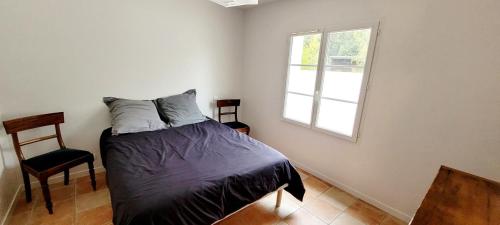 a bedroom with a bed and a window and a chair at La Maison Des Conches - Ref 803 in Longeville-sur-Mer