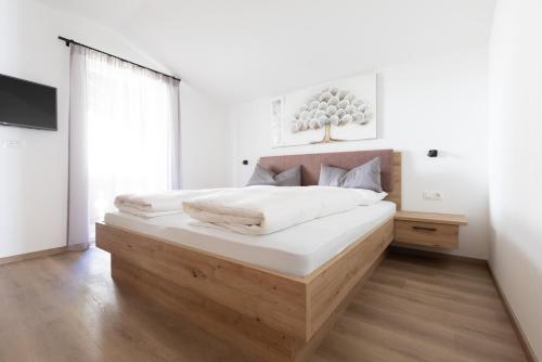 a bedroom with a large bed with a wooden headboard at Kleon 4 in Rifiano