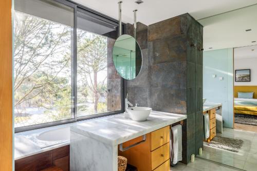 a bathroom with a tub and a sink and a mirror at Tróia Villa Paradise in Troia