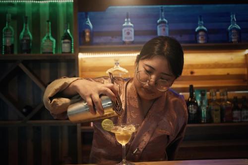 a woman is preparing a drink in a bar at Norbu Lingka Resort in Tongsa