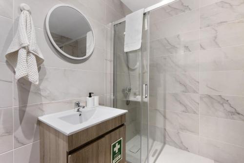 a bathroom with a sink and a shower with a mirror at Refugio Das Vinhas in Celorico de Basto