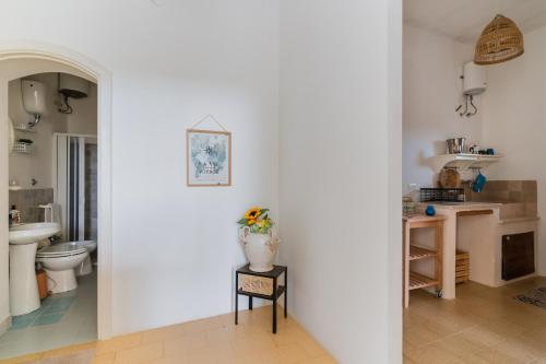 a bathroom with a toilet and a vase of flowers on a table at Villa Camilla a Otranto in Otranto