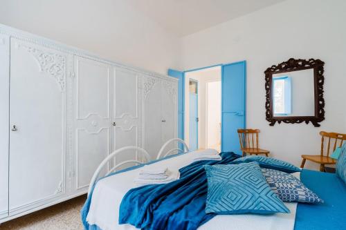 a blue and white bedroom with a bed and a mirror at Villa Camilla a Otranto in Otranto