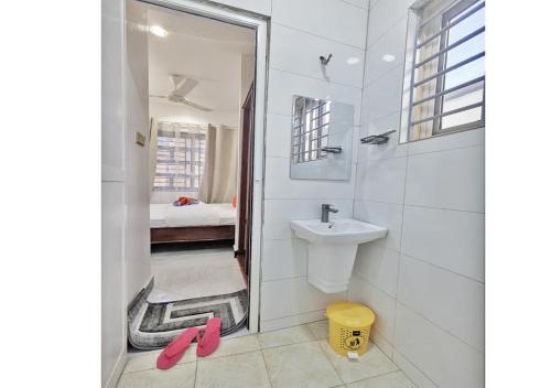 a bathroom with a sink and a shower with pink slippers at Salpat Camp Lodge in Moshi