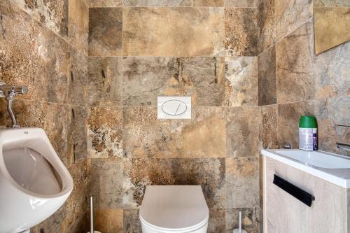 a bathroom with a toilet and a sink and a urinal at Park Carpe Diem Studio in Busot