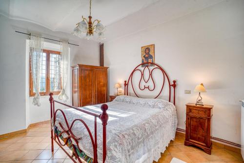 a bedroom with a large bed and a chandelier at Col Di Metino - Umbria in Gualdo Tadino
