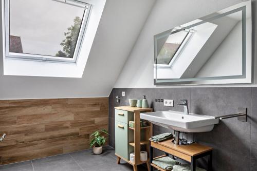 a bathroom with a sink and two windows at Ferienhaus Ebringen in Ebringen