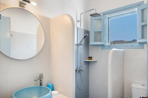 a bathroom with a sink and a shower with a mirror at Pico Bello Patmos 30 in Patmos