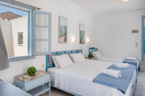 a bedroom with a white bed and a window at Pico Bello Patmos 30 in Patmos