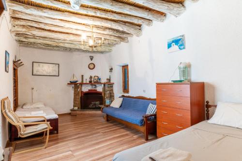 a bedroom with a blue bed and a fireplace at Andros Traditional House in Andros
