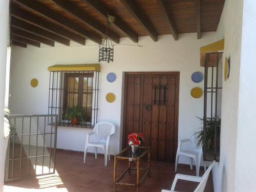 a porch with two chairs and a wooden door at Casa Villazo 2 in Málaga