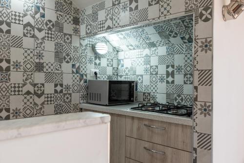 a kitchen with a stove and a microwave at Monolocale Arredato - Le Terrazze in Ribera