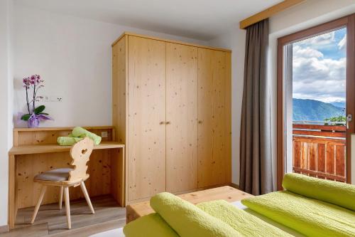 a bedroom with a desk and a chair and a window at Forchnerhof Apt Rose in Maranza