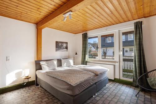 a bedroom with a bed and a large window at Ferienwohnung Huckelberg in Schmallenberg