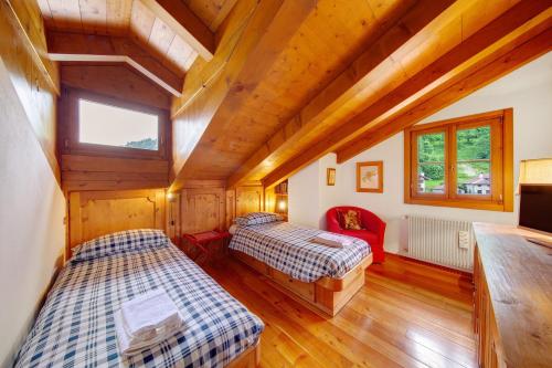 two beds in a room with wooden ceilings at Casa San Giovanni 2 a Vinigo in Vinigo