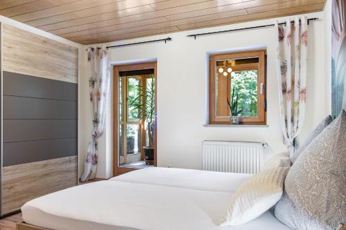 a bedroom with two beds and two windows at Landhaus Echerschwang in Bernbeuren