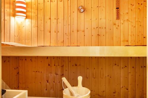 a bathroom with a wooden wall with a bucket at Landhaus Echerschwang in Bernbeuren