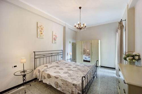 a bedroom with a bed and a chandelier at Appartamento La Buraggia in Diano San Pietro