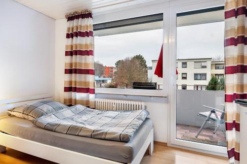 a bedroom with a bed and a large window at Szafranzimmervermietung in Winnenden