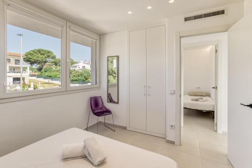 a bedroom with white walls and a purple chair at Apartamento ático en L'Escala in L'Escala