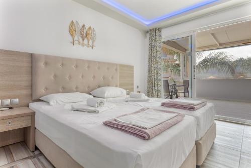 a bedroom with a large white bed with towels on it at Villa Dionysia Studio S2 in Alikanas