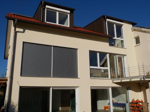 a house with large windows and blinds on it at Ferienwohnung Haus Maria in Wäschenbeuren