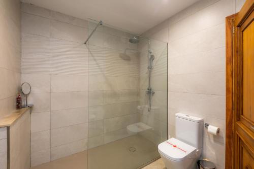 a bathroom with a toilet and a glass shower at Finca Goet in Sa Pobla