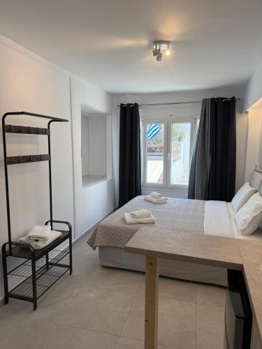 a small bedroom with a bed and a window at Nice & cosy central studios in Mikonos