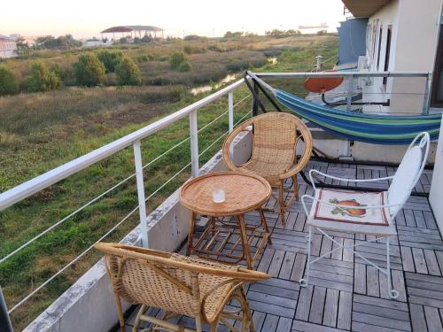 a balcony with a table and chairs and a hammock at Jonah by The Sea Hideaway Cabin in Ban Sam Maitri