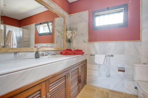 a bathroom with a sink and a mirror and a toilet at Villa Capricho in Lanzarote