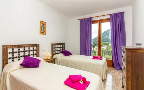 a bedroom with two beds with purple pillows at Puig in Pollença