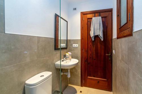 a bathroom with a toilet and a sink and a mirror at Puig in Pollença