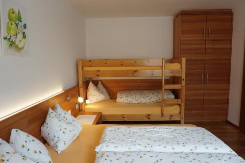 a bedroom with a bed and a bunk bed at Waalhof Ferienwohnung Apfelblüte in Silandro