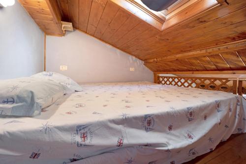 a large bed in a room with a wooden ceiling at Mansarda Dei Pescatori in Imperia